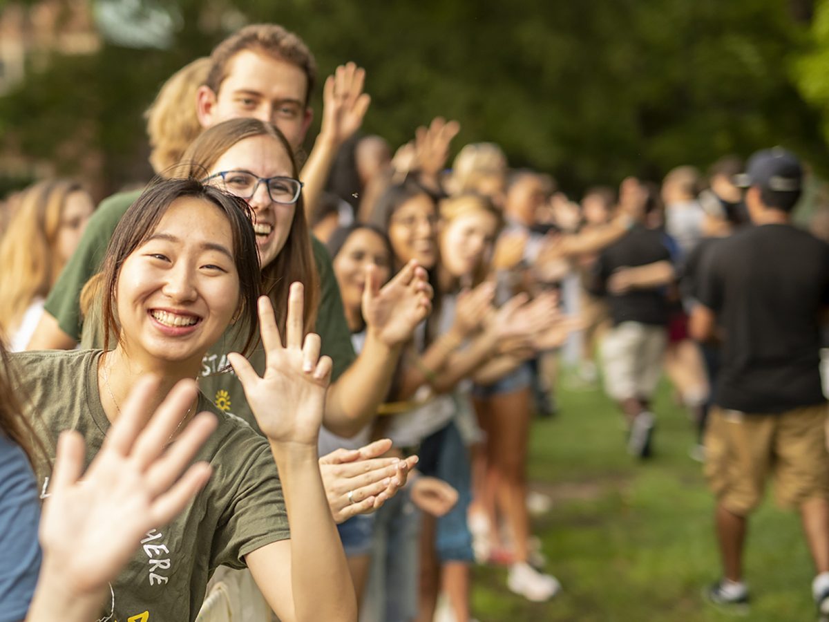 students showing the VU hand sign at Founders Walk